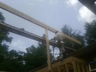 Carpenter setting a ridge beam over a new addition frame — Ice Dam Removal by Roofing Brothers in Hendrum