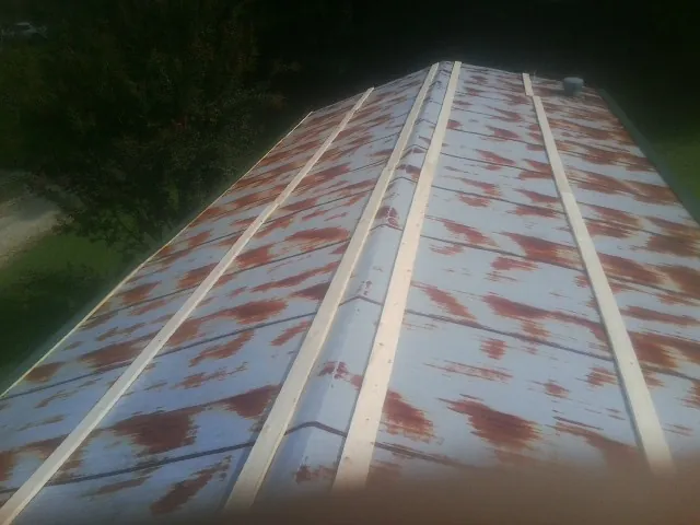 Rusted metal roof panels with new wood purlins before replacement — Storm Damage Roof Repair in Hendrum by Roofing Brothers
