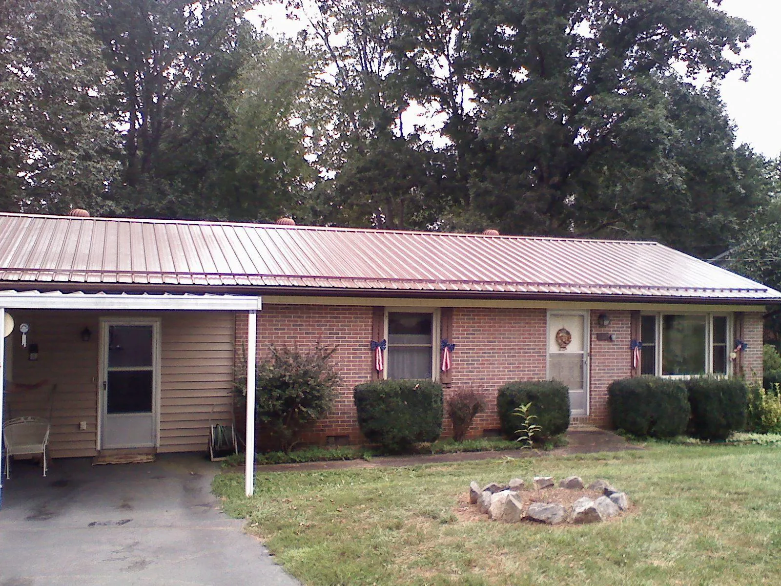 Bronze metal roof and carport on a brick ranch home — Roof Repair work by our crew in Hendrum